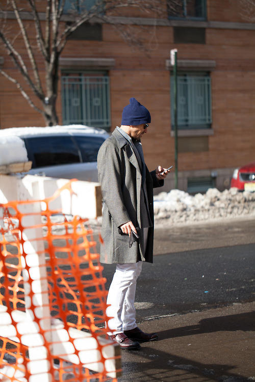 man wearing white chinos and gray coat