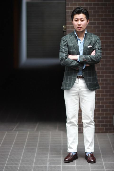 man wearing white chinos and green plaid coat
