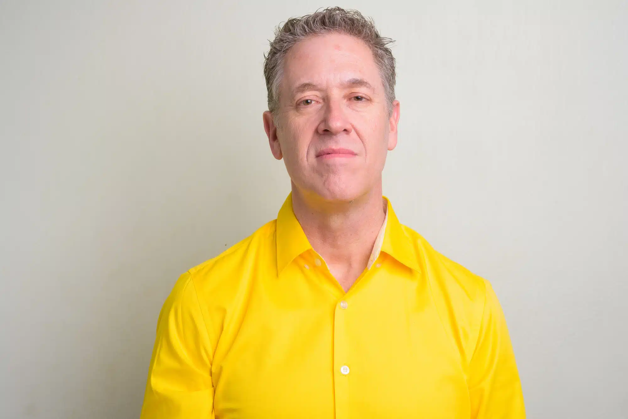 Portrait of mature businessman wearing yellow shirt