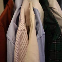 An assortment of dress shirts hanging in a sequence