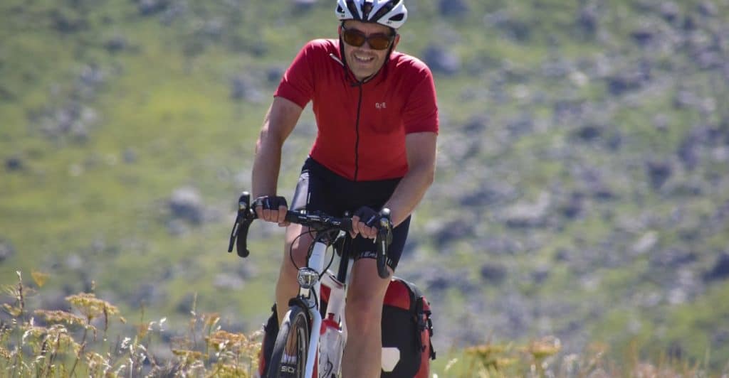 A smiling cyclist in red enjoying a ride.