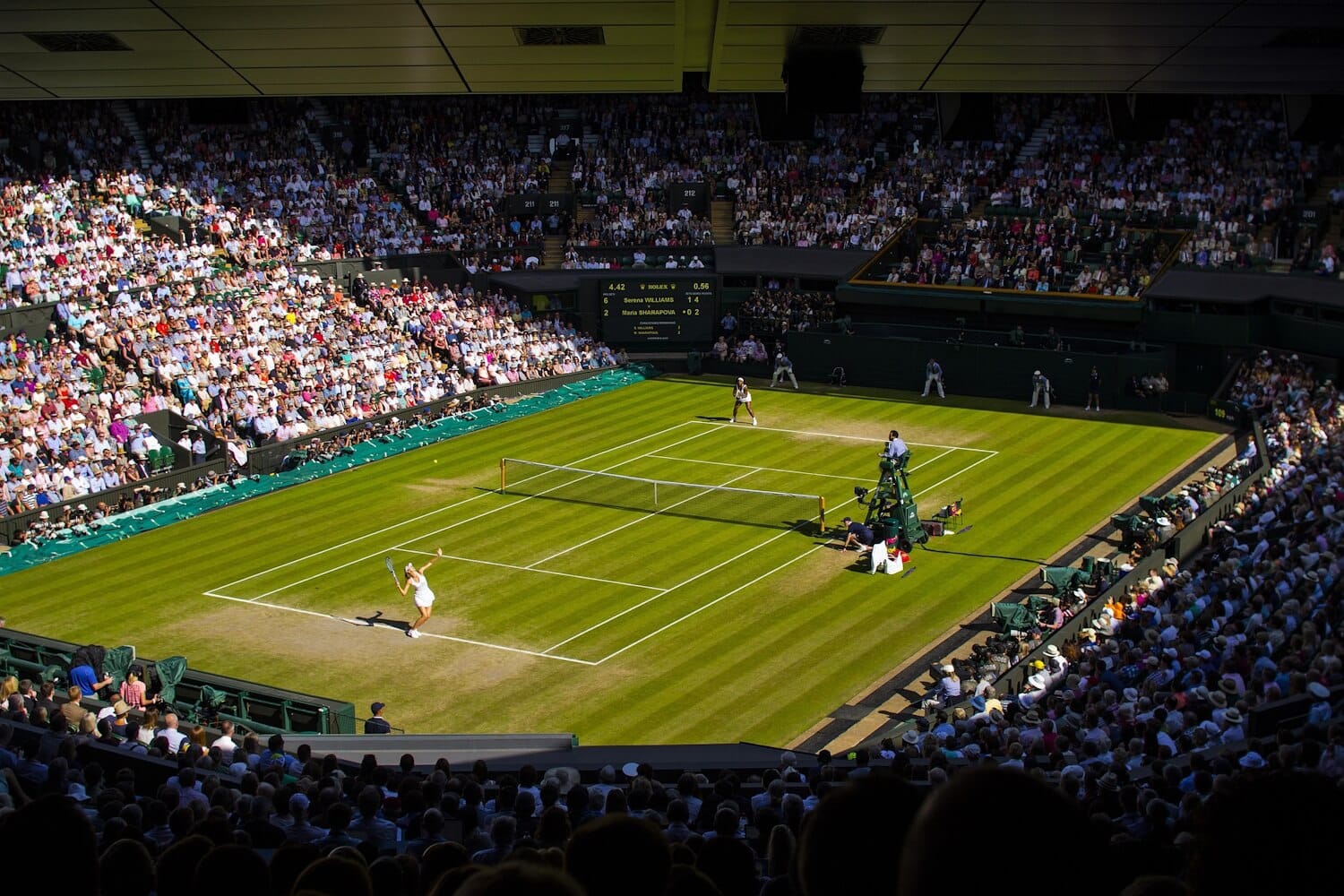 A tennis match underway with full stands.