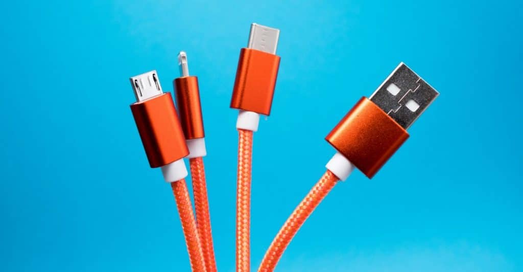 Close-up of several USB cables with different connector types against a blue background.