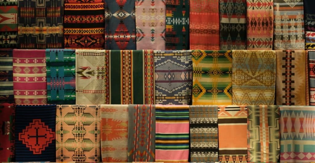 A detailed view of various colorful and patterned fabrics, highlighting texture and design.