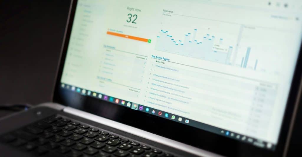 A laptop screen showing a dashboard with various data points and graphs.