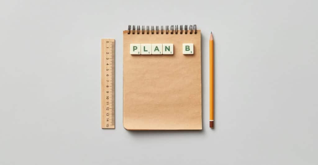 A notebook with the words "Plan B" spelled out in Scrabble tiles, along with a ruler and pencil.