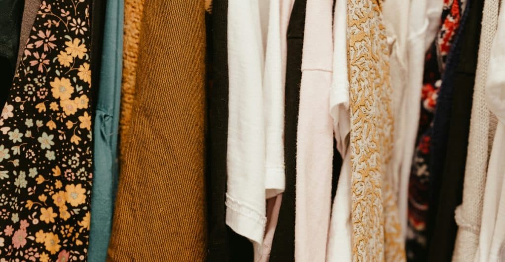 A close-up view of a clothing rack filled with garments in different colors and patterns.