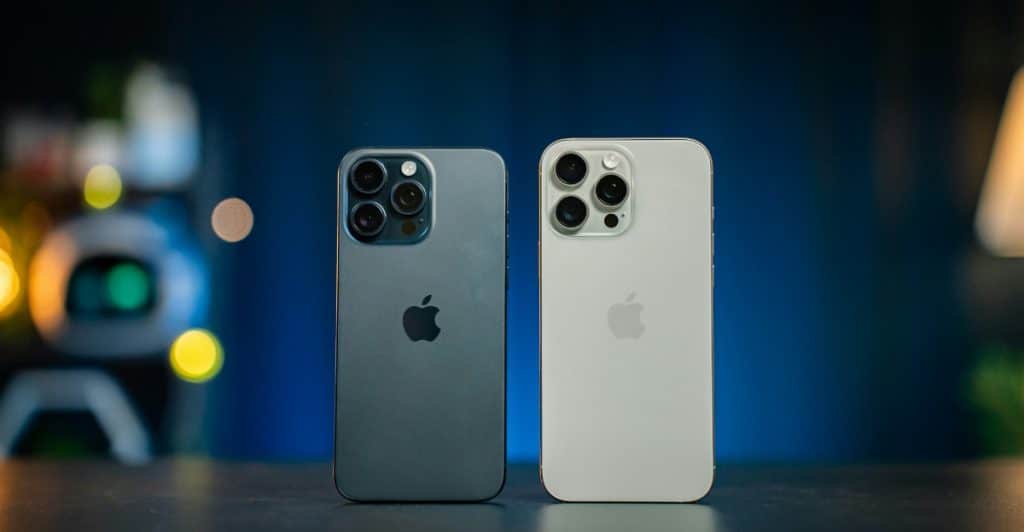 Two Apple iPhone 16 Pro Max phones are placed side-by-side on a table.