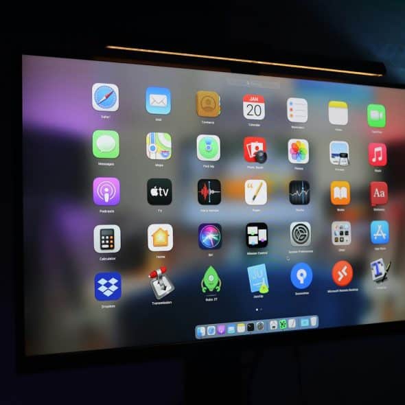 A large screen displays a variety of application icons, suggesting a range of software tools.