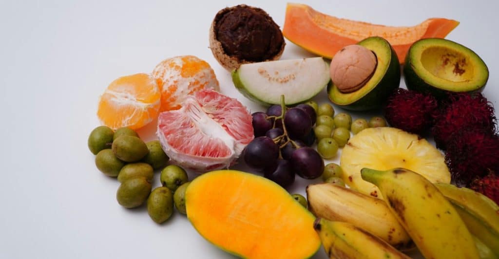 An overhead shot of a variety of colorful fruits on a white surface.