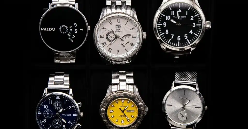A collection of six wristwatches in a display case, featuring different styles and bands.