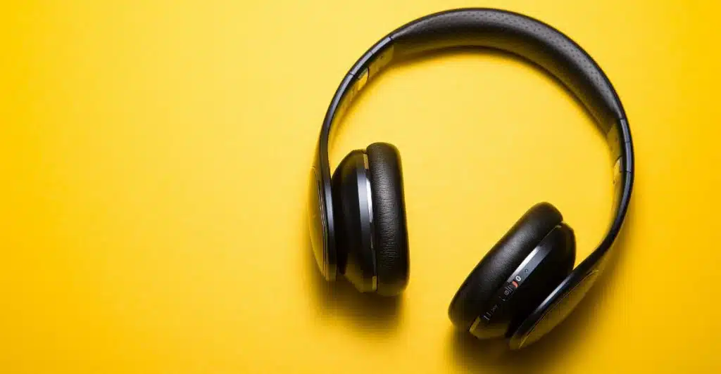 Black over-ear headphones on a yellow background.