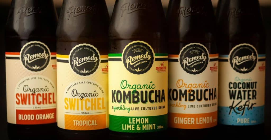 Five dark glass bottles of "Remedy Kombucha" in various flavors lined up.