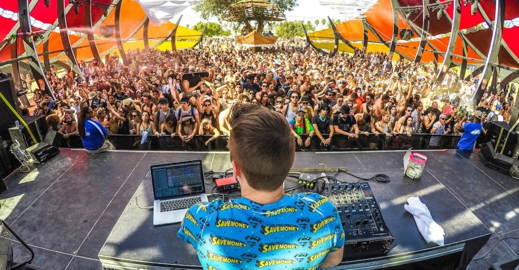A DJ performing in front of a large crowd at Coachella.