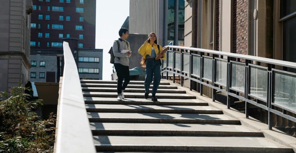 A man and a woman are sitting at a table in an office, having a conversation.