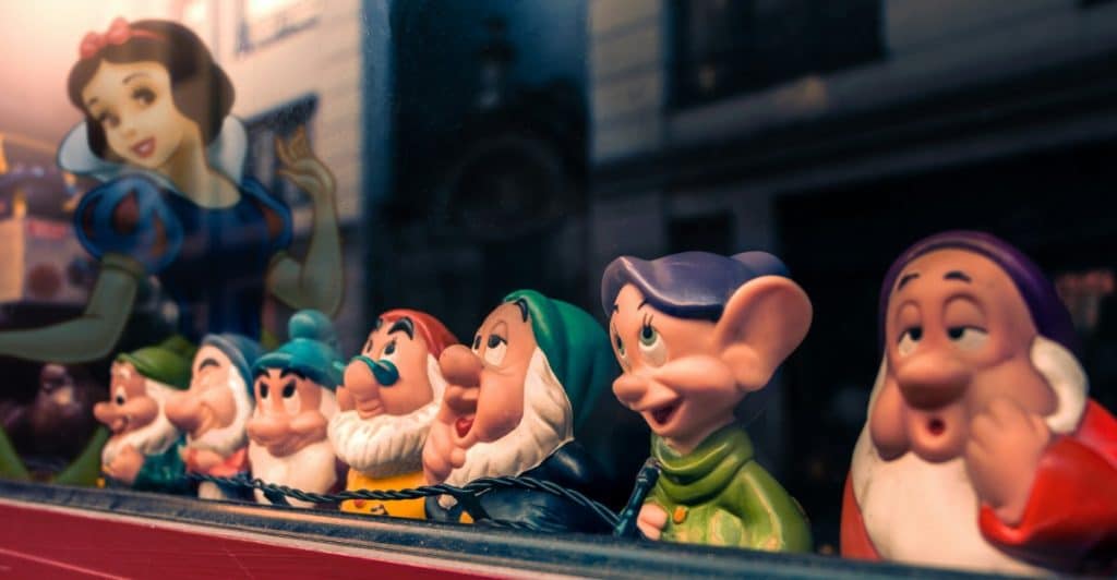  A display of Disney figurines, including Snow White and the Seven Dwarfs, in a store window.