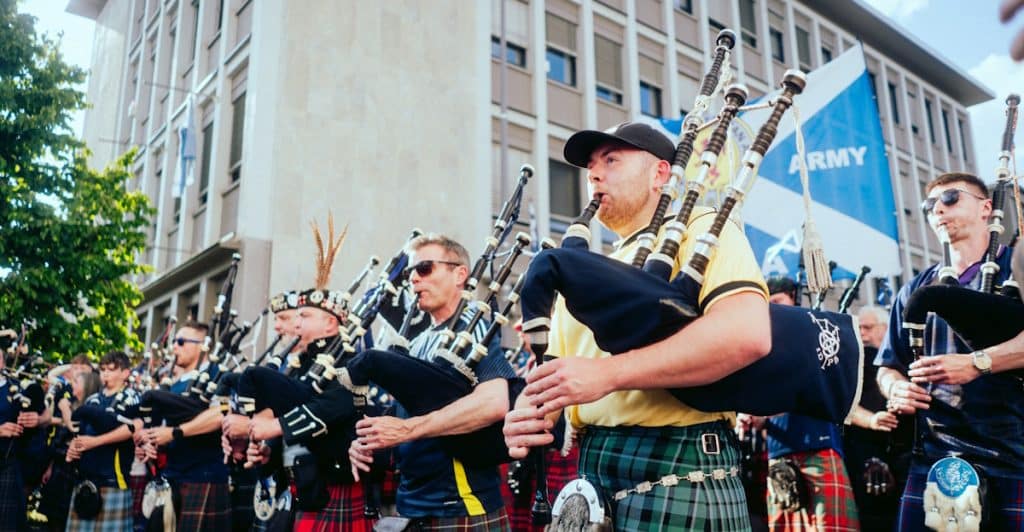 A group of bagpipers performing in kilts at the Edinburgh Festival Fringe.