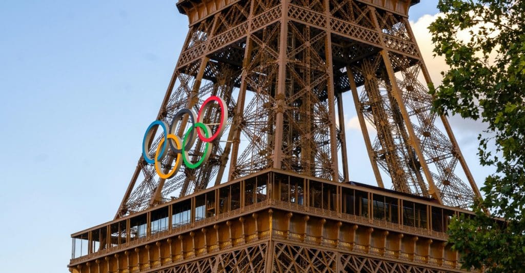 A partial view of the Eiffel Tower in Paris with the Olympic rings mounted on its side.