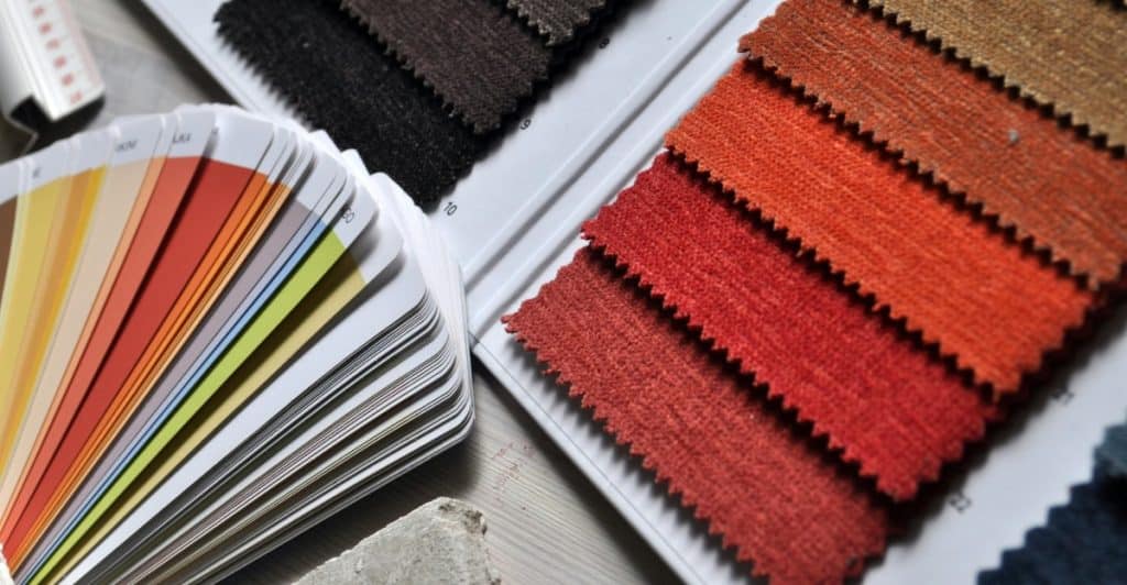 Close-up of fabric swatches in various colors and textures, along with color fan decks.