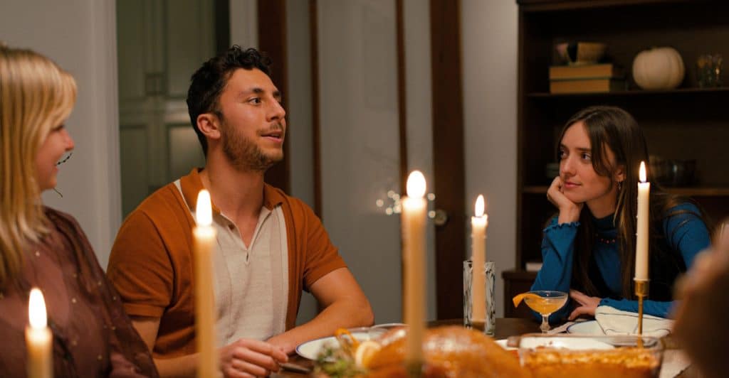 A family gathered around a table, having a dinner with candles lit.