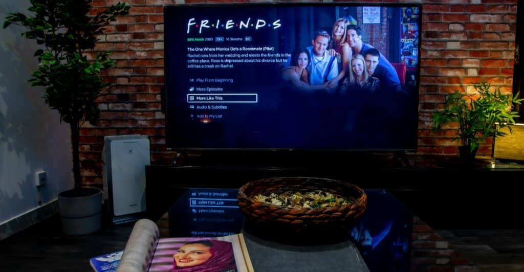 A TV screen displaying the title "Friends" and the cast of the show.