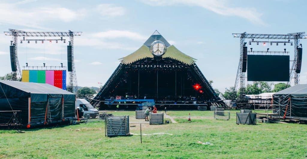The Pyramid Stage at Glastonbury Festival with a clock and large screens.