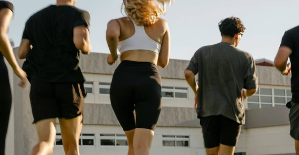 A group of people running together on an outdoor track or field.