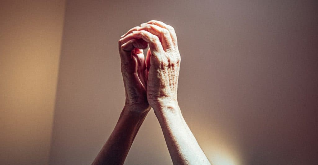 A close-up shot of two hands clasped together