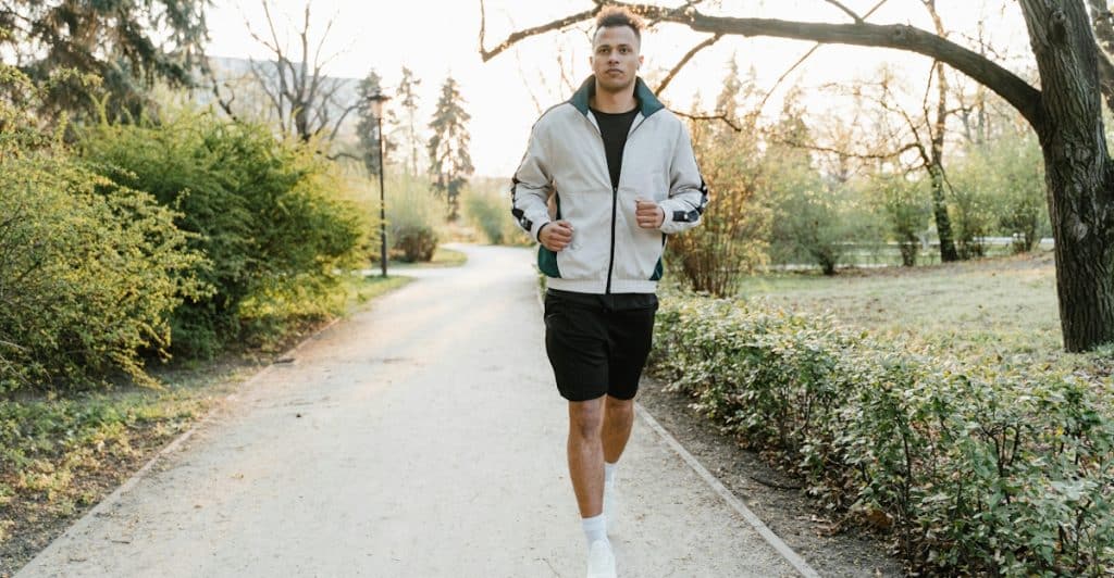 A man jogging on a path in a park.
