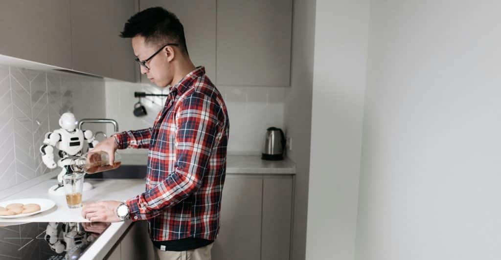 A person in a kitchen preparing a drink.