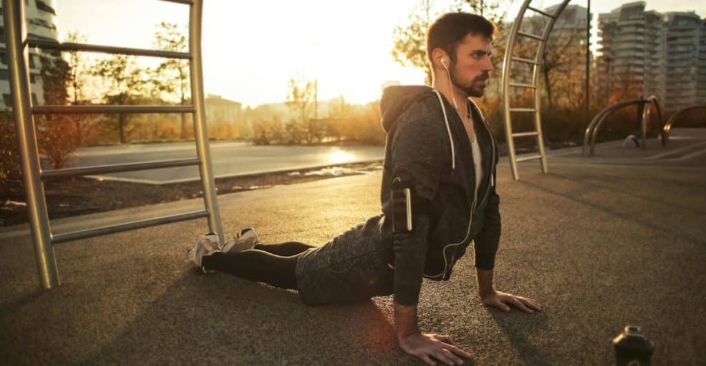 A man stretching outdoors in the morning.