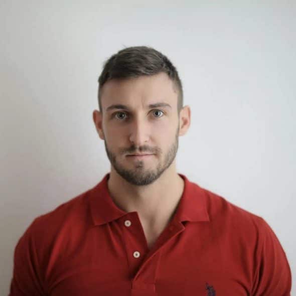 A handsome man wearing a red polo shirt.