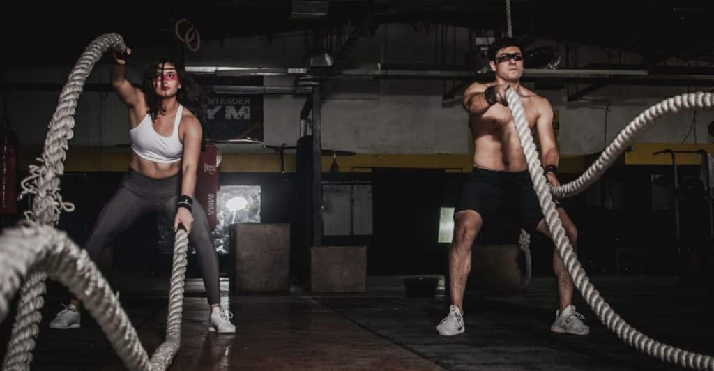  Man and Woman Doing Battle Rope Exercises.