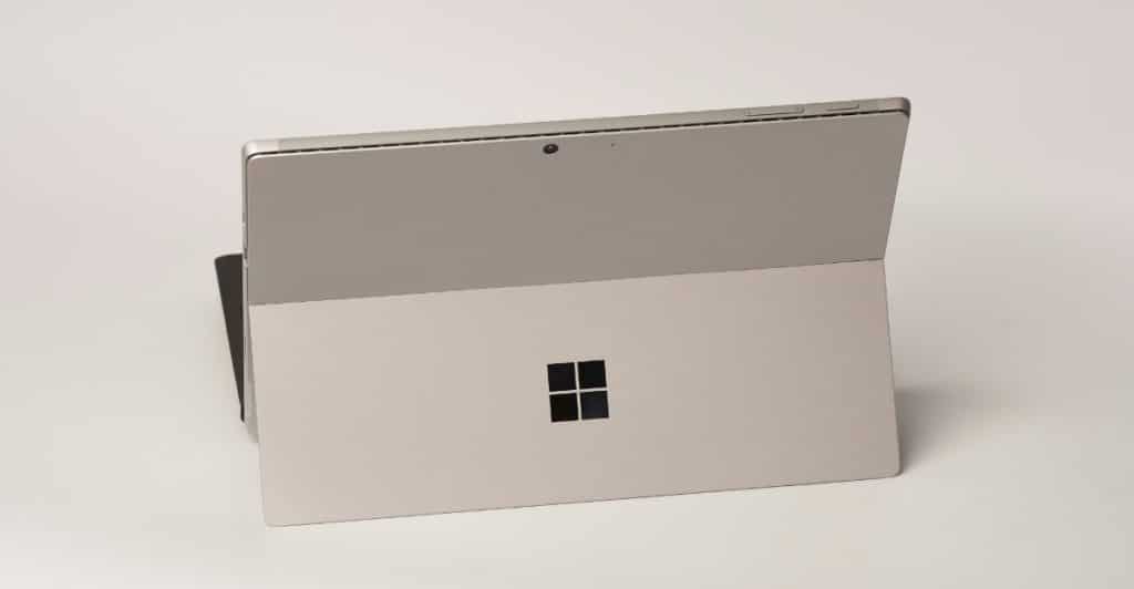 A three-quarter rear view of a silver Microsoft Surface Pro 11 with its kickstand partially open, against a plain white background.