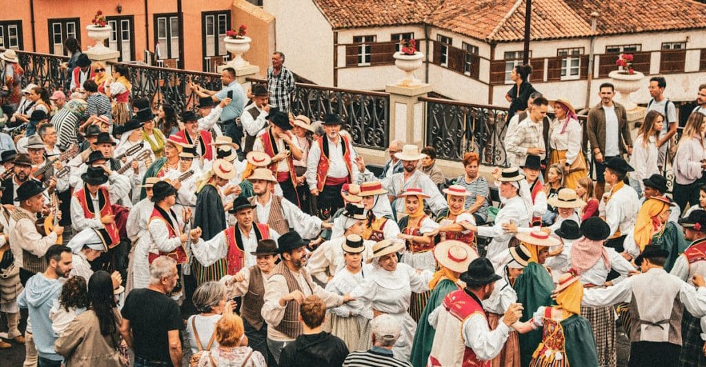 A crowd of people in traditional clothing dancing at Oktoberfest.