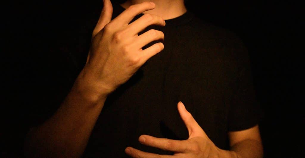 A close-up shot of a person's hands gesturing in front of their chest.