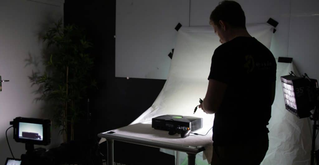 A person setting up electronic equipment in a studio-like environment.