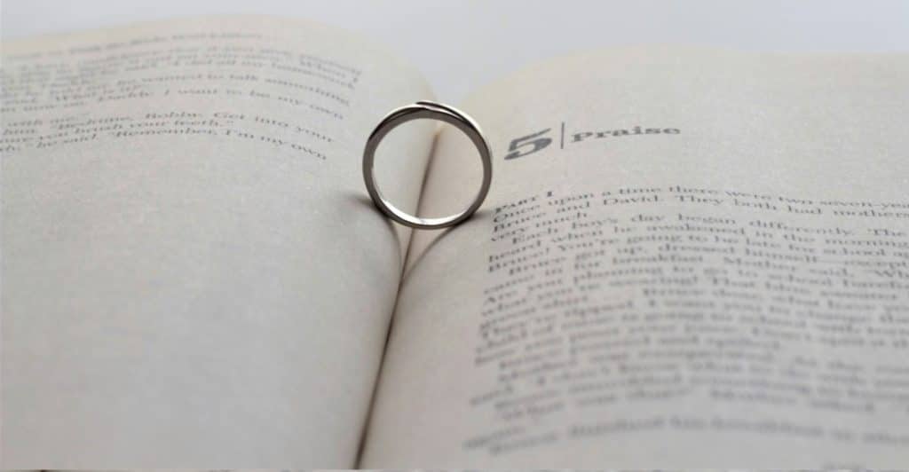 A close-up of an engagement ring placed inside an open book.