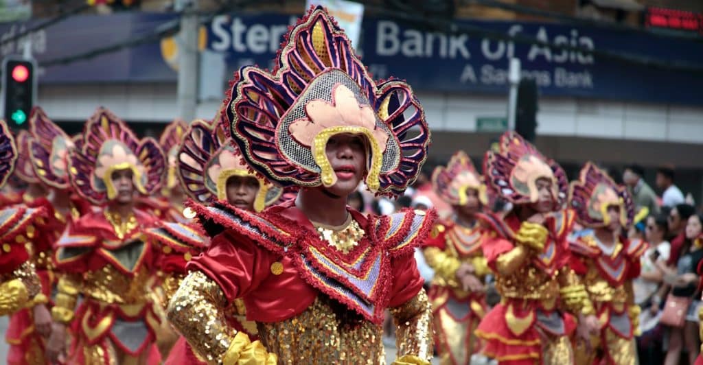 Performers in colorful costumes dancing in the Sinulog Festival parade.