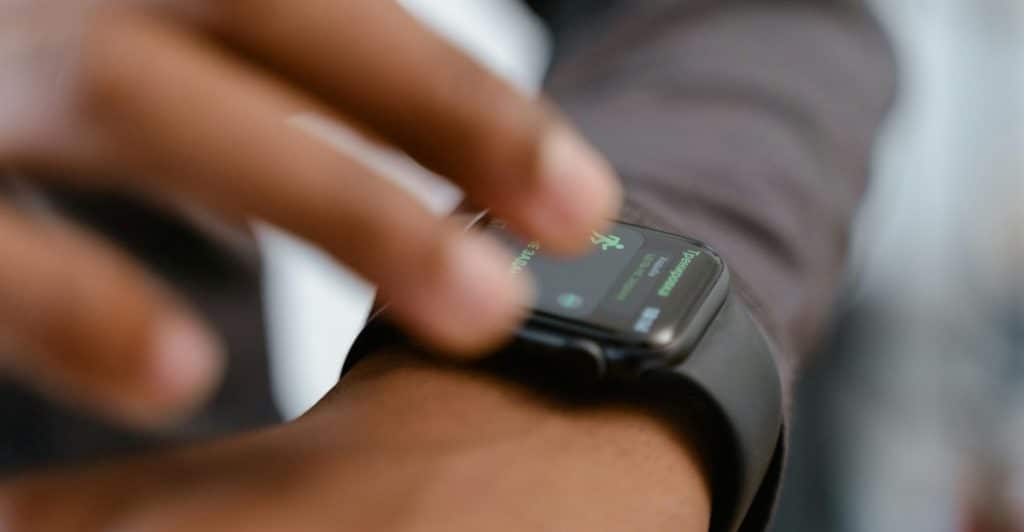 Close-up of a hand wearing a smartwatch that is displaying health data.