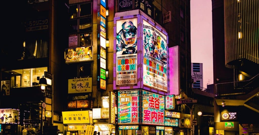  Busy street in Tokyo with digital signboards and pedestrians at night.