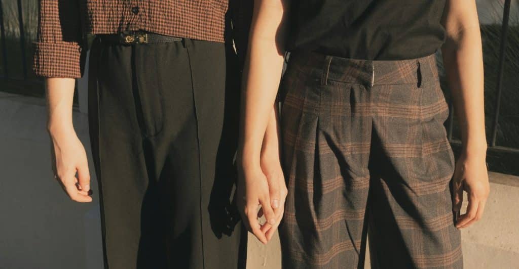 A close-up of two people's hands clasped together at the waist, suggesting connection and learning about each other.