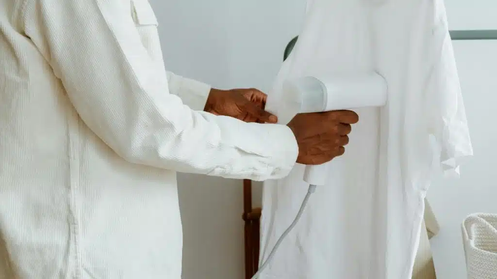A man steaming his shirt.