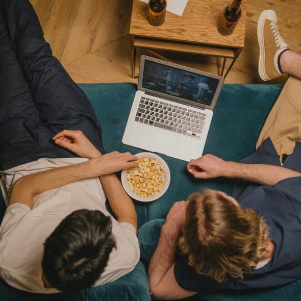 Friends watching a film through a laptop.