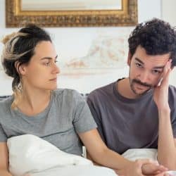 A man with a thoughtful expression, looking down, suggesting contemplation or sadness.