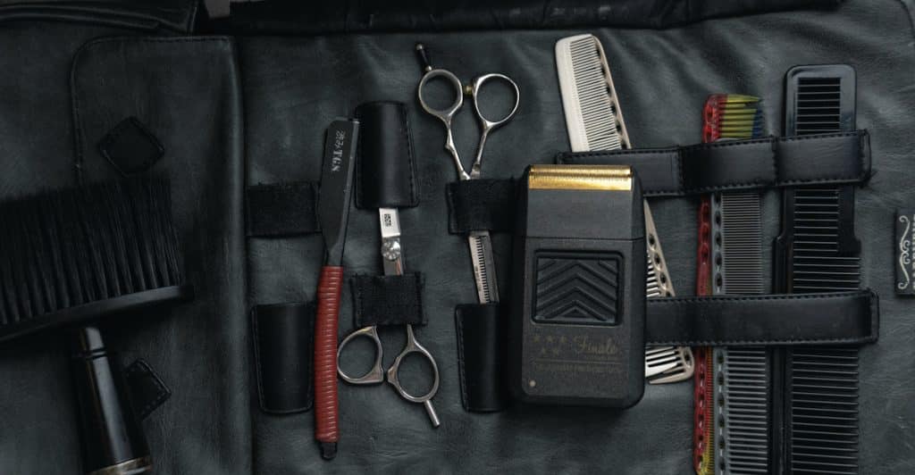 A grooming kit is open, displaying various tools like scissors, combs, and an electric shaver