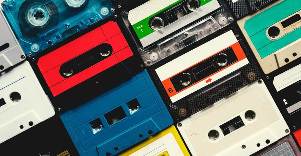 A close-up, overhead view of a scattered collection of various colorful retro cassette tapes.