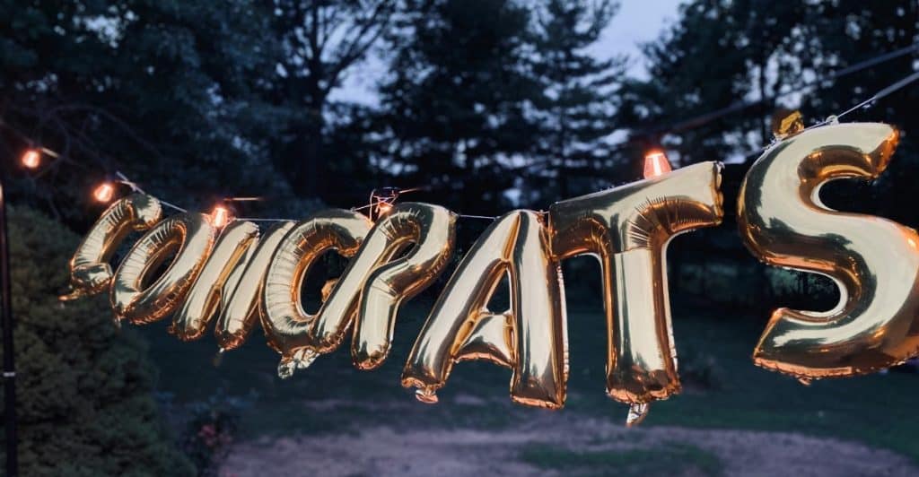Gold "Congrats" balloons strung up outdoors