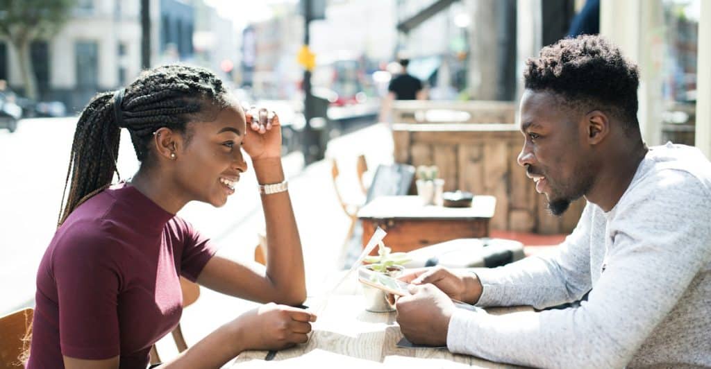 A couple chatting at an outdoor café.