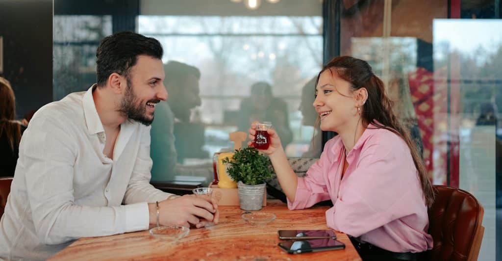 A couple smiling while having tea at a café.